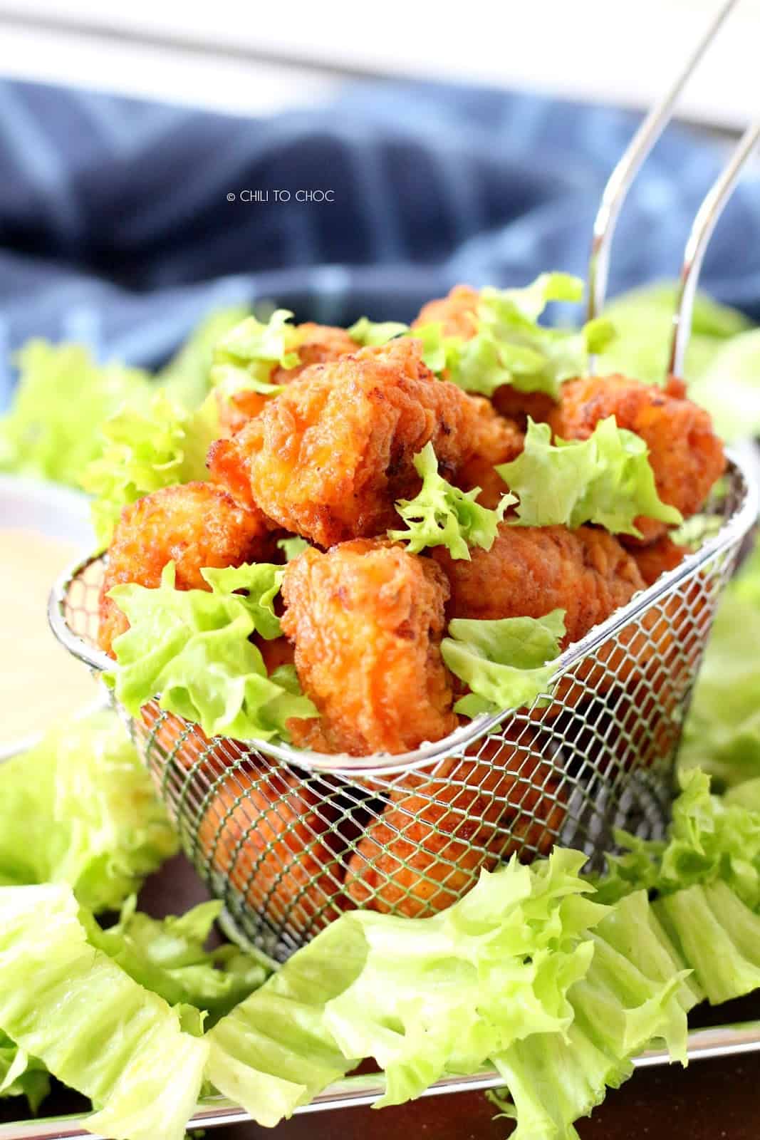 Popcorn chicken in a fries basket garnished with lettuce.