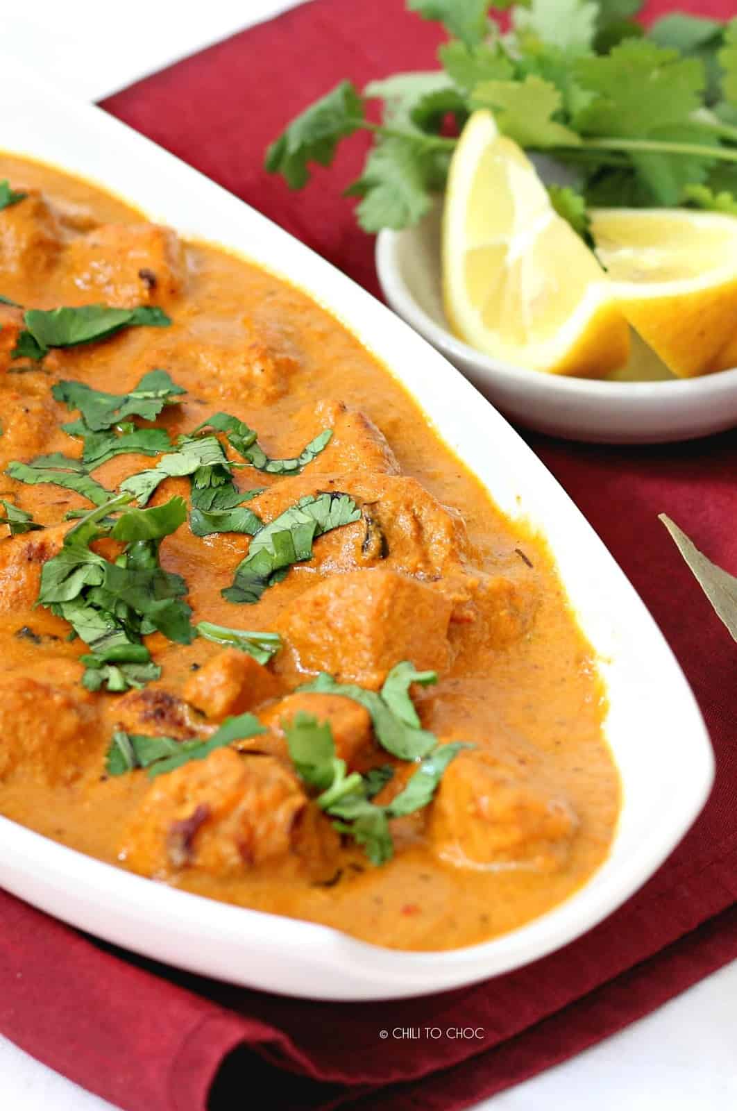 Close up of chicken tikka masala in a white dish.