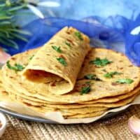 A stack of Besan ki Roti garnished with coriander