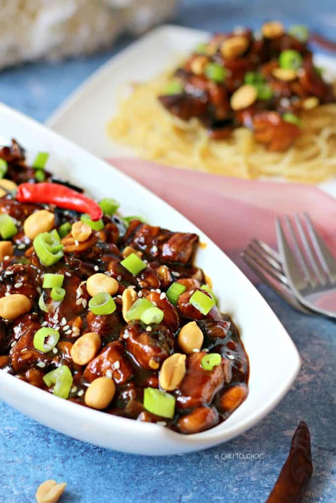 Close up of Kung Pao Chicken garnished with peanuts and spring onion