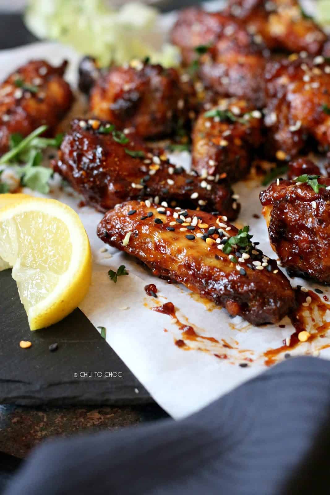 Closeup of sticky wings garnished with toasted sesame seeds.