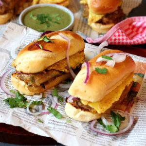 Bun Kabab on a newspaper with green chutney behind it