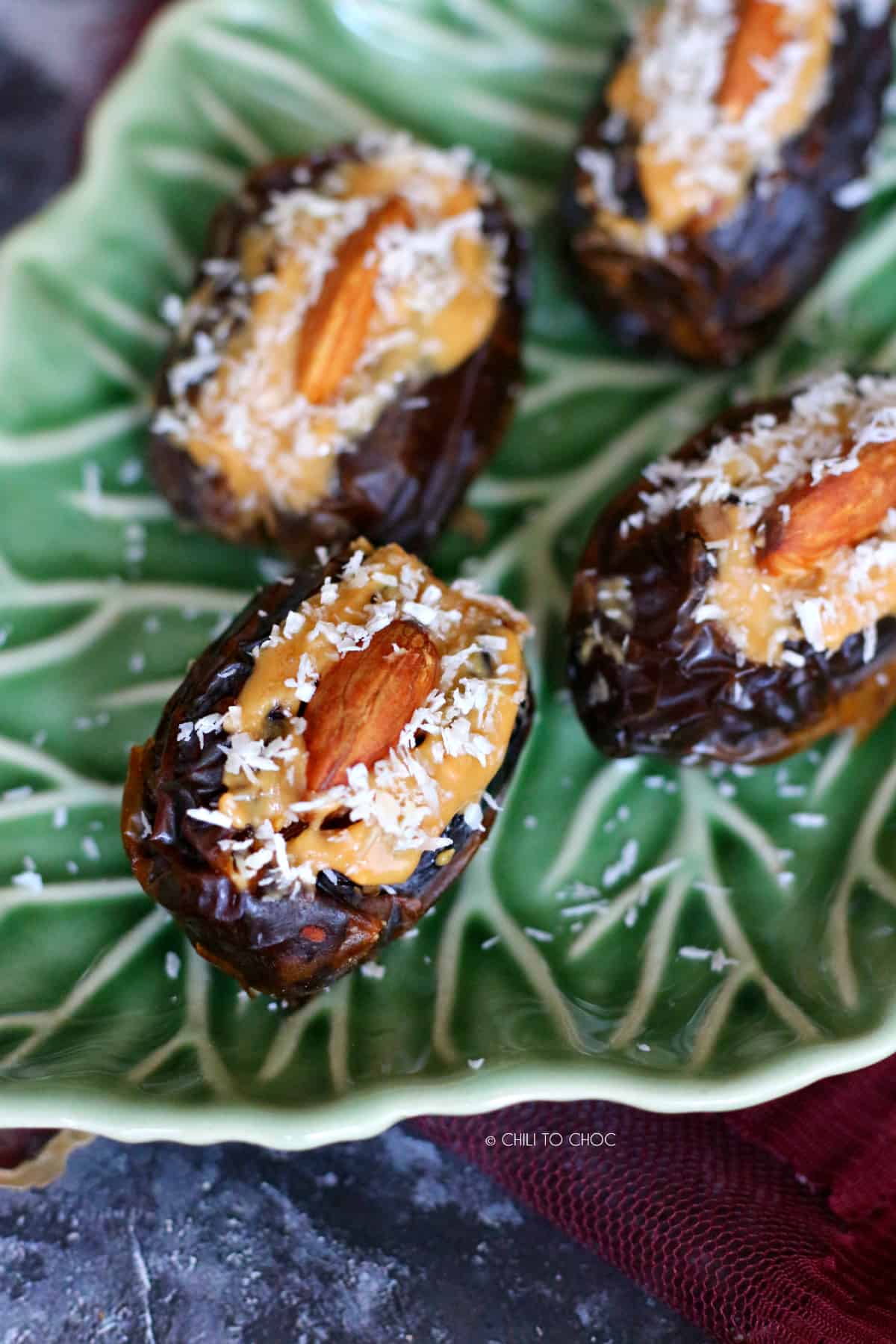 closeup of stuffed date with peanut butter, almond and coconut flakes