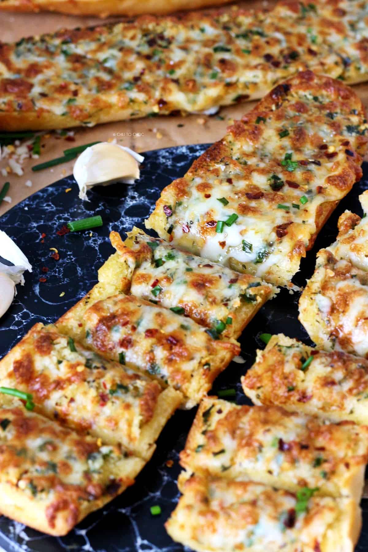 Slices of cheesy garlic bread with chives on top