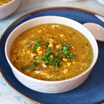 Chicken Corn Soup in a bowl garnished with sweet corn and spring onion.