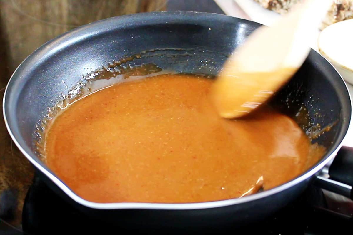 Mixing the hones sriracha sauce in the pan.