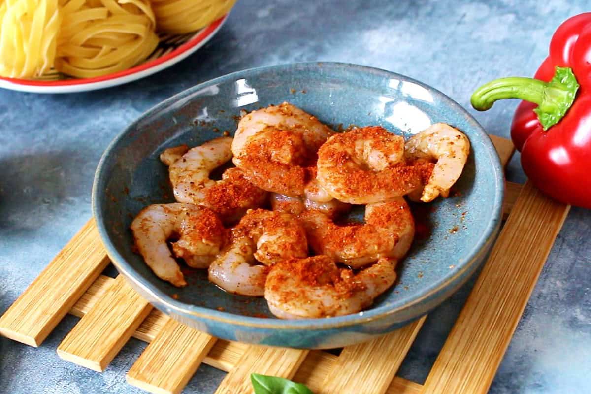 Seasoned shrimp on a blue plate.