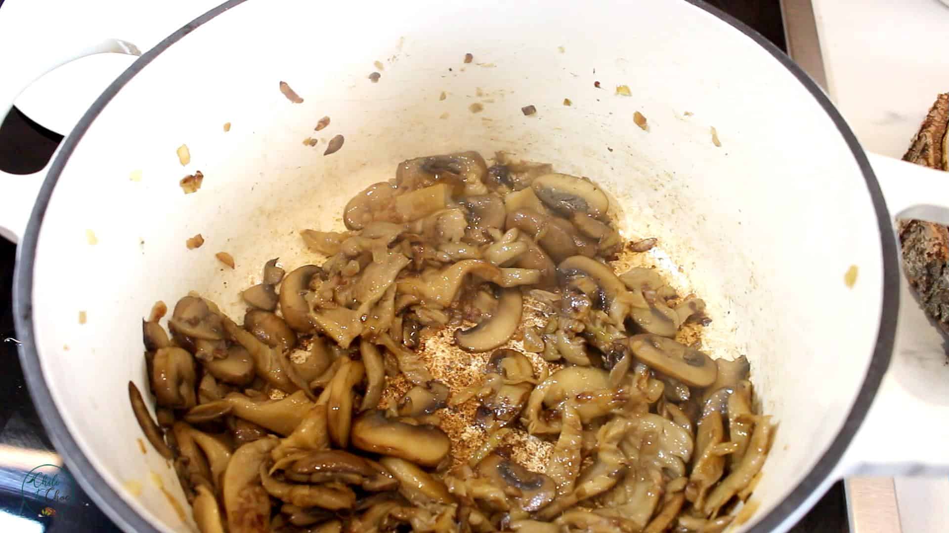 Sauteed mushroom in a white dutch pot.