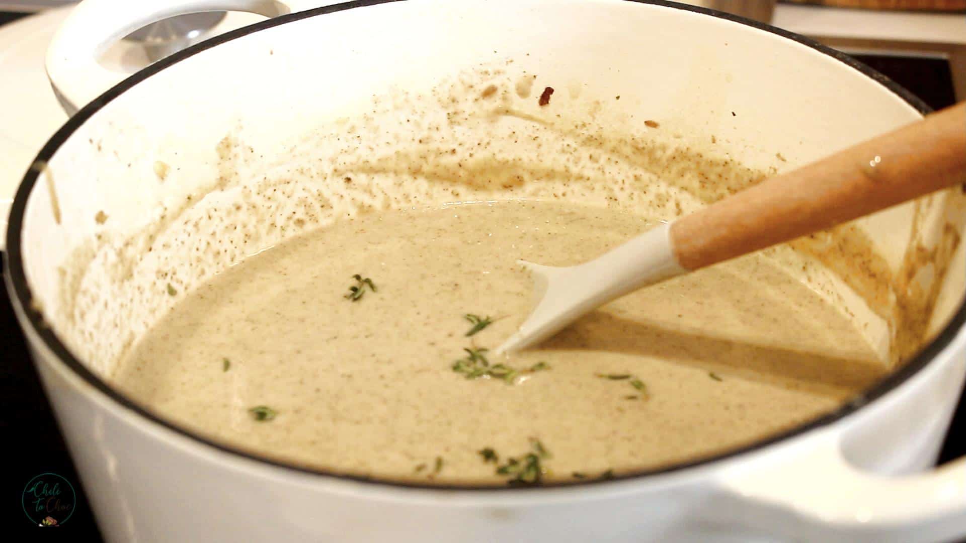 Stirring mushroom soup in a dutch pot.