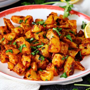 Batata Harra in a plate garnished with cilantro.