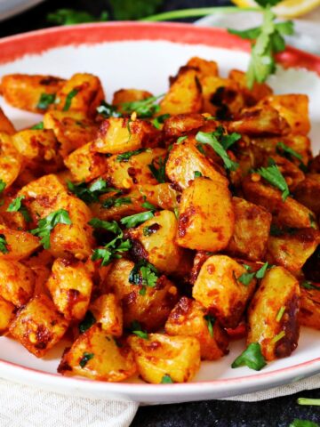 Batata Harra in a plate garnished with cilantro.