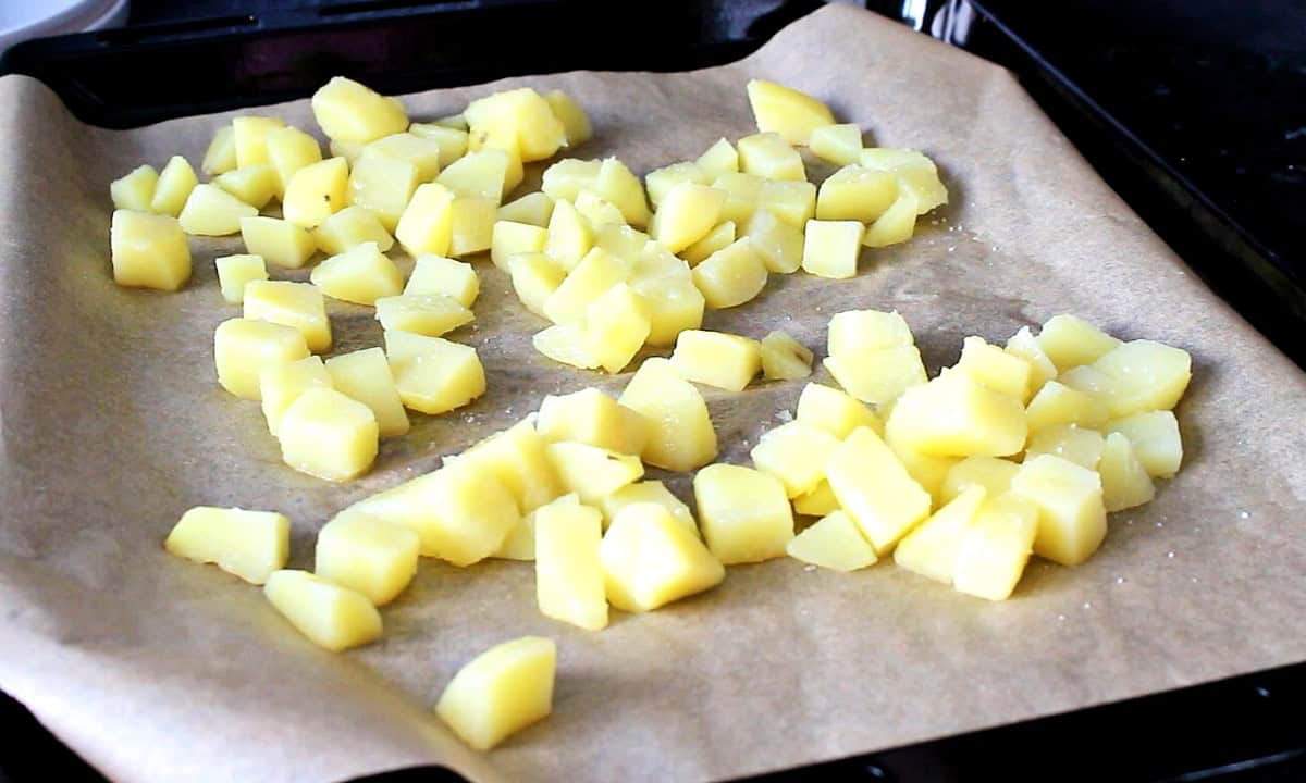 Blanched potatoes on a baking tray.