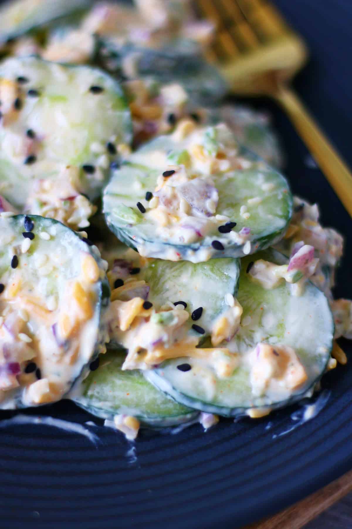 Closeup of creamy cucumber salad with a fork in the background.