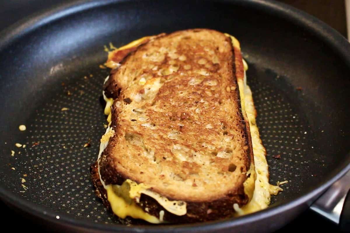 Browned grilled cheese sandwich in a pan.