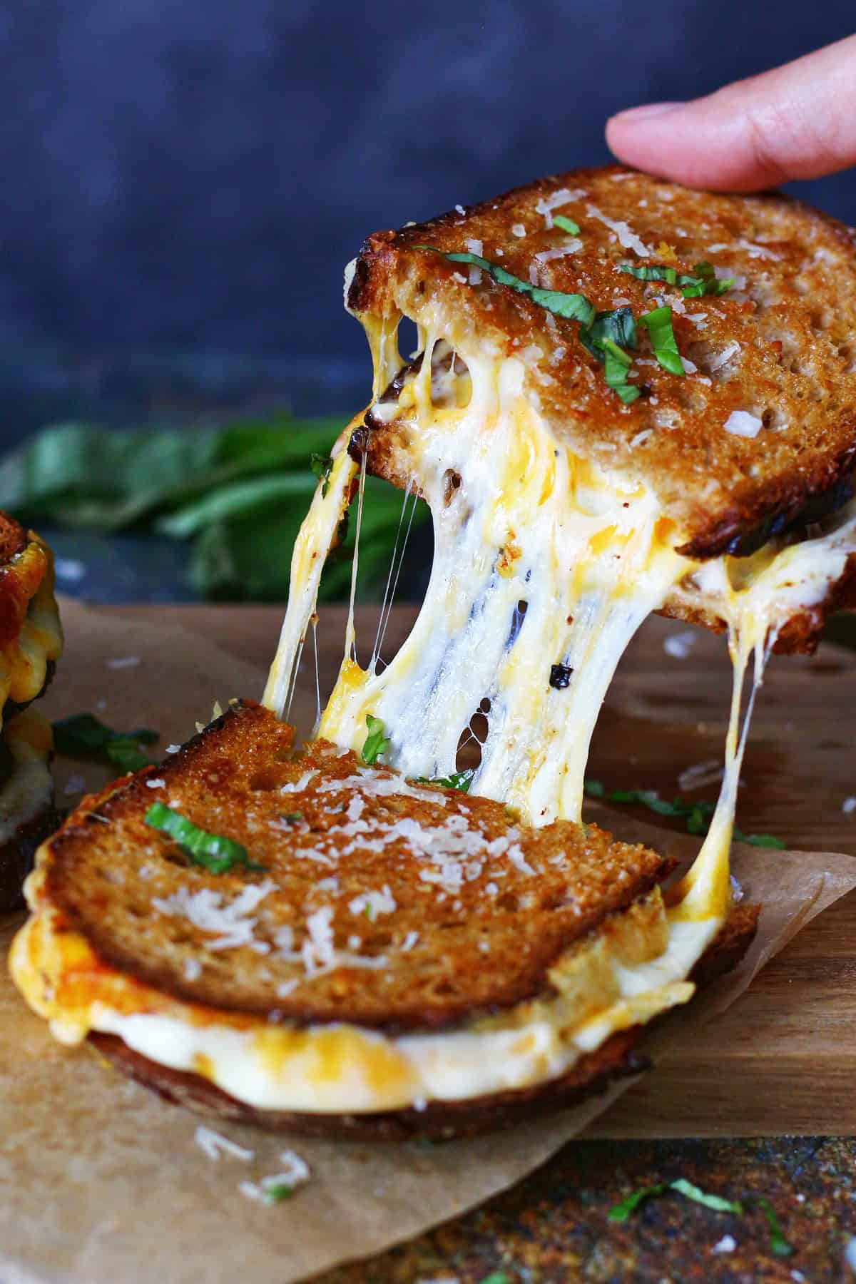 Cheese pull between two halves of grilled cheese sandwich.