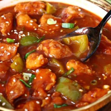 Serving spoon in Chicken Manchurian with bell peppers and sauce.