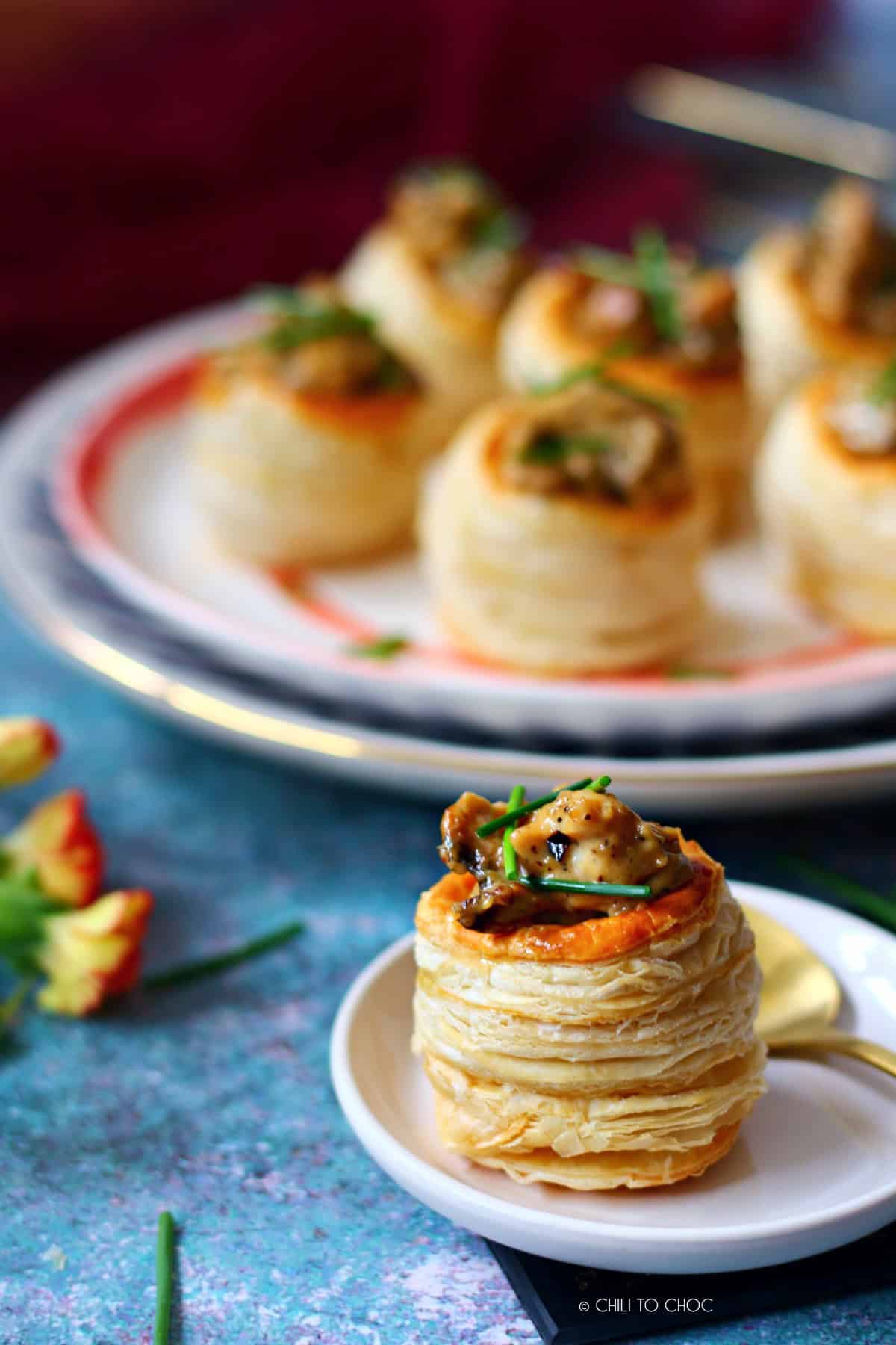 A chicken and mushroom vol au vent with a gold spoon on the side.