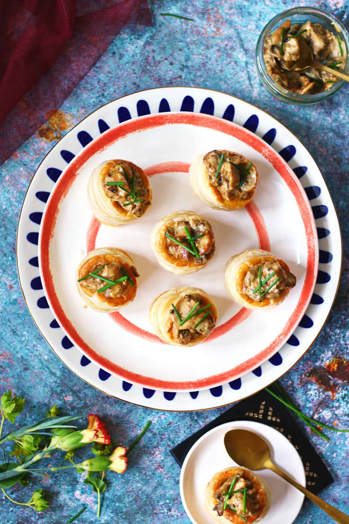 A group of vol au vents on a plate with creamy filling on the side.