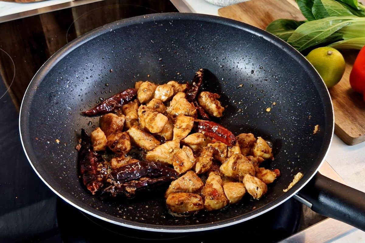 Chicken and chilies cooking in a wok.