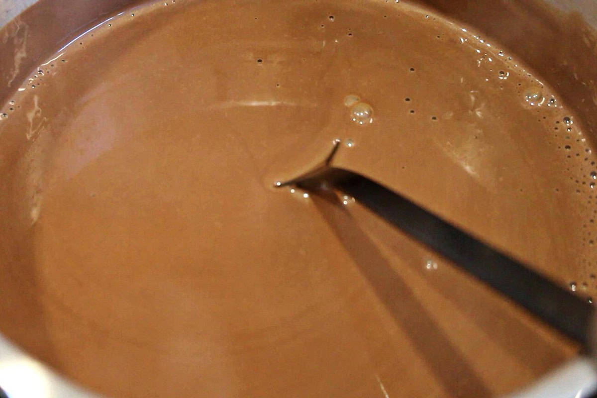 Thick hot chocolate with a black spoon in it.