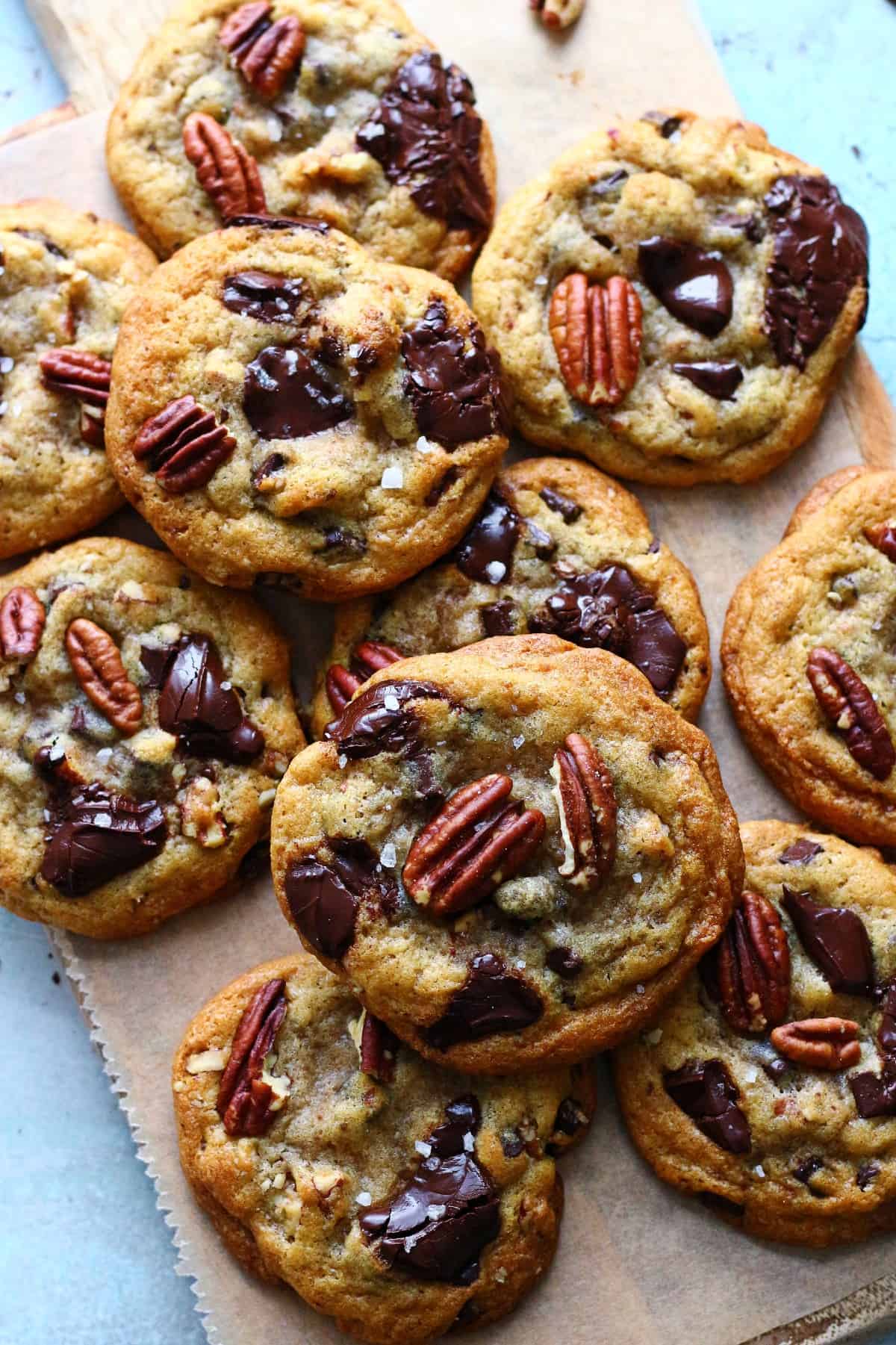 A pile of chocolate pecan cookies on parchment paper.