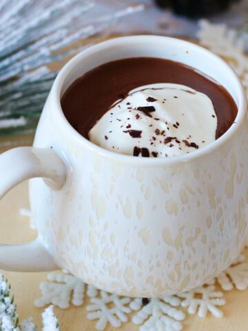 French Hot Chocolate in a white mug topped with whipped cream.