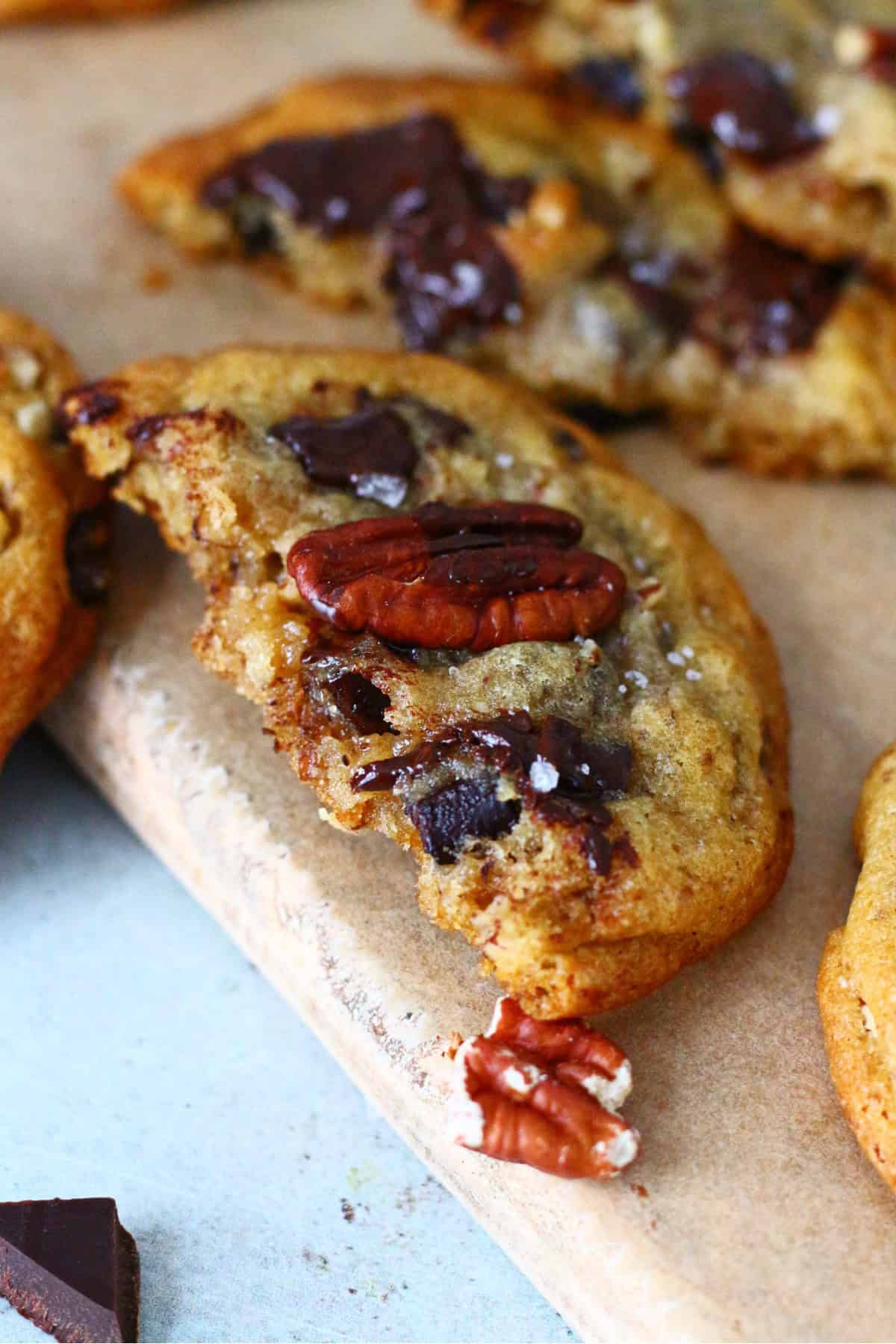 Half of a cookie with melted chocolate, sea salt and toasted pecan.