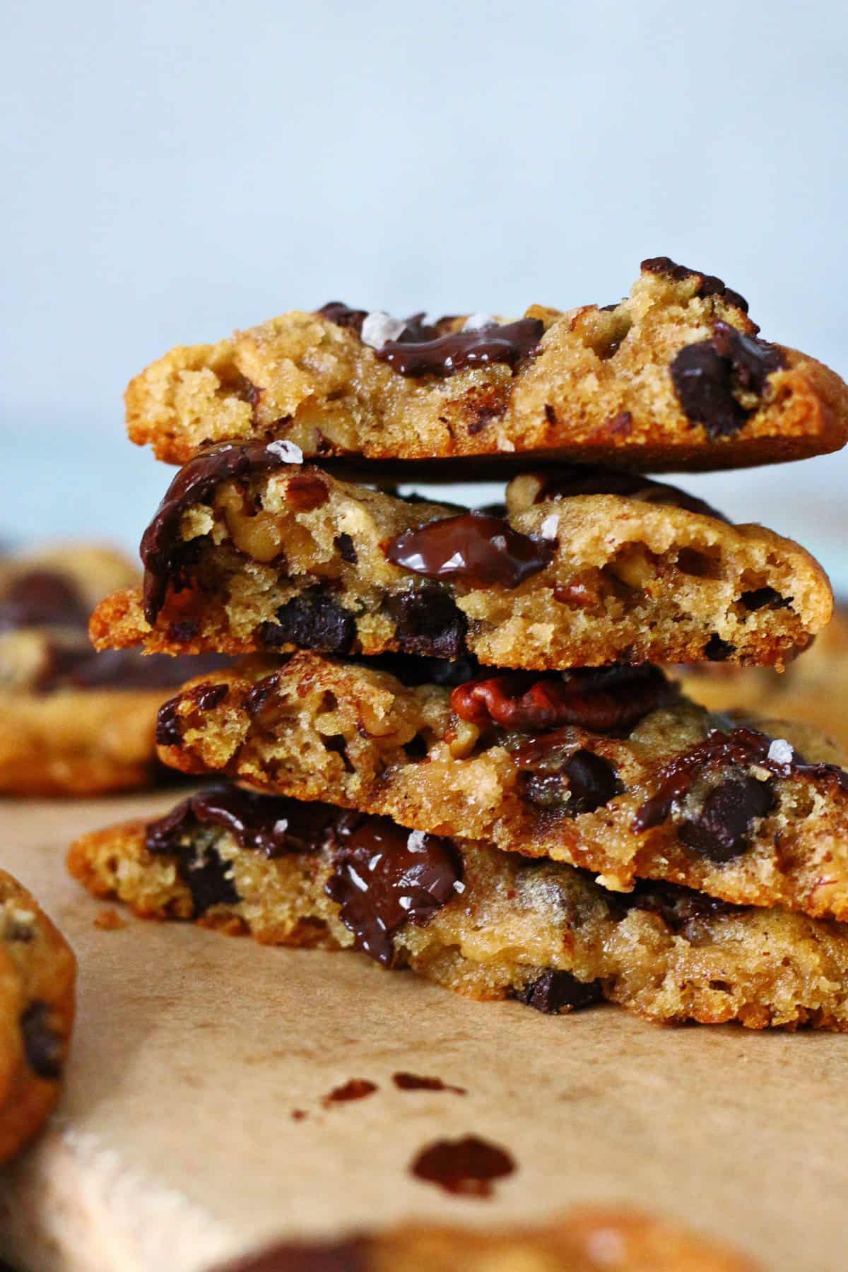 Four halves of chocolate chip pecan cookies stacked on top of each other.