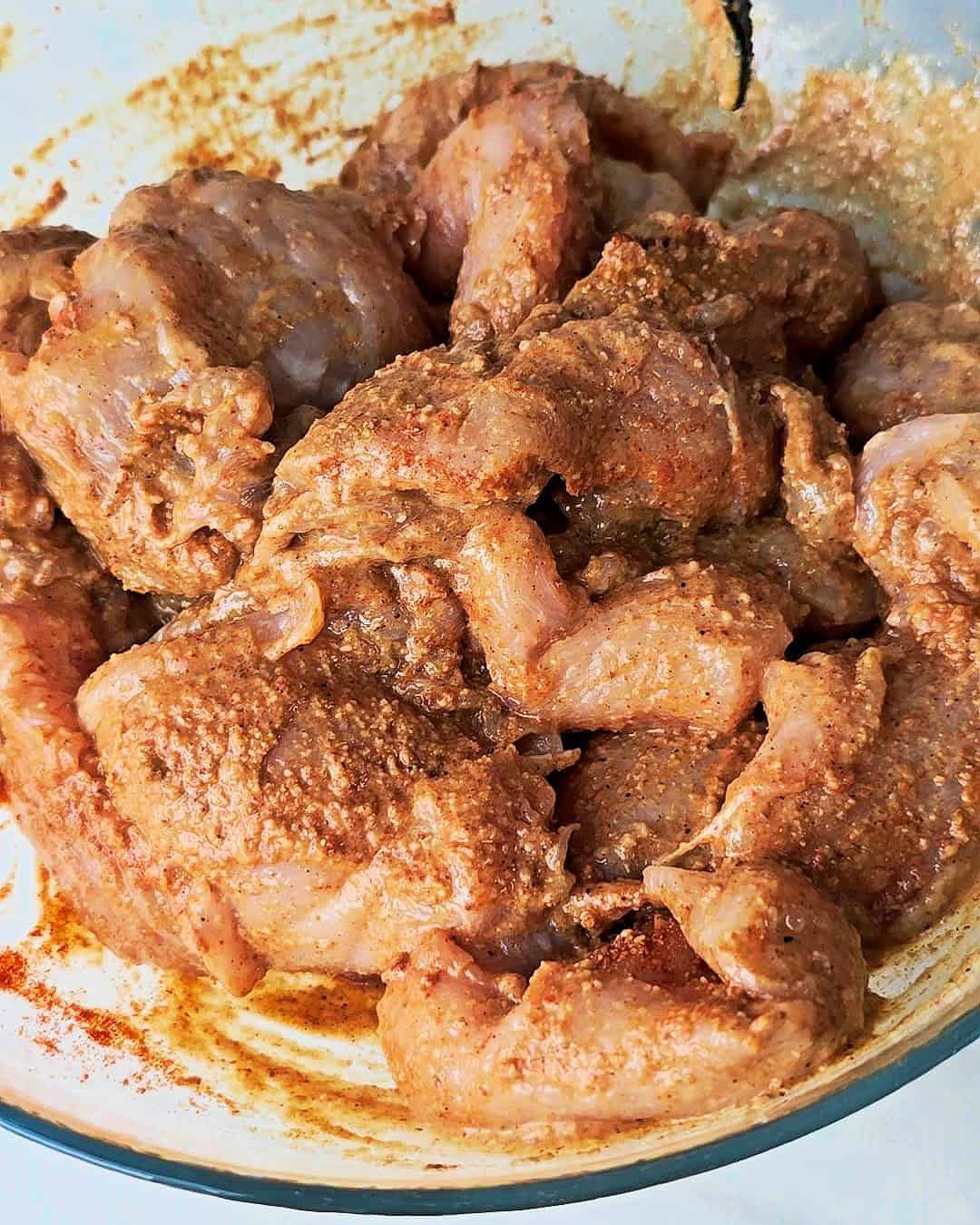 Marinated chicken in a glass bowl.