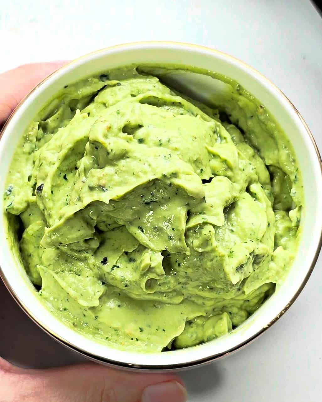 Blended avocado sauce in a white bowl.