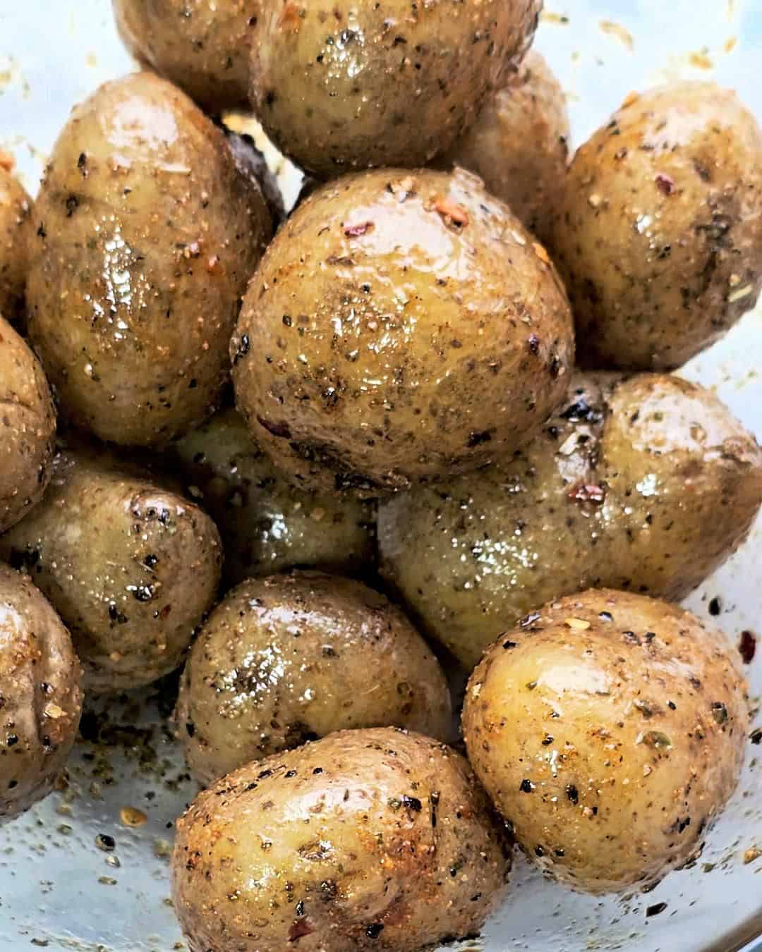 Potatoes tossed into seasoned oil.