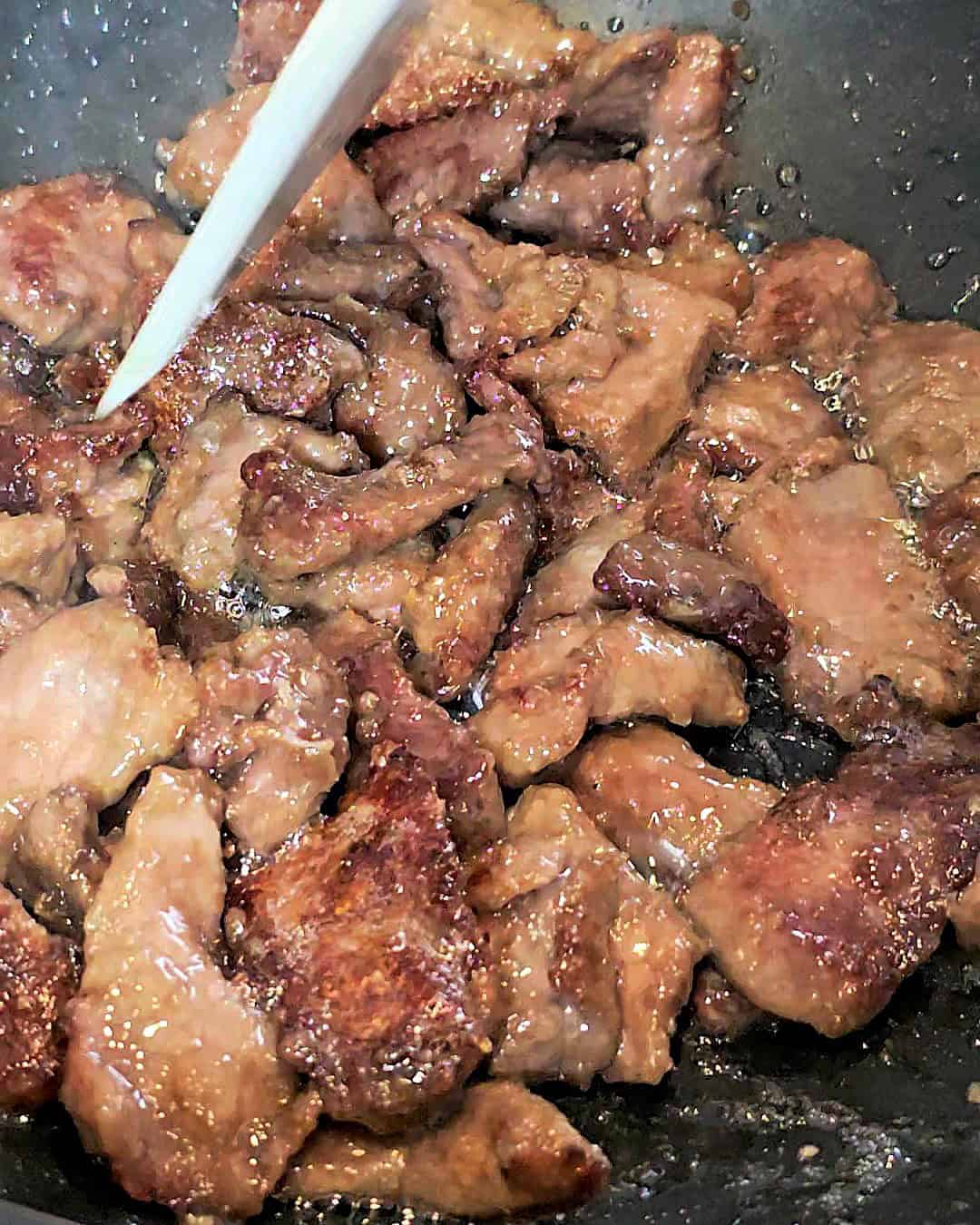 Frying beef strips in a wok.