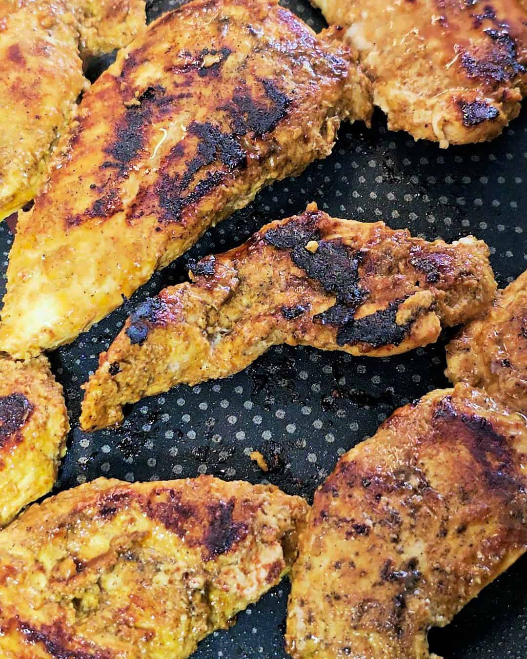 Grilling chicken strips in a pan.