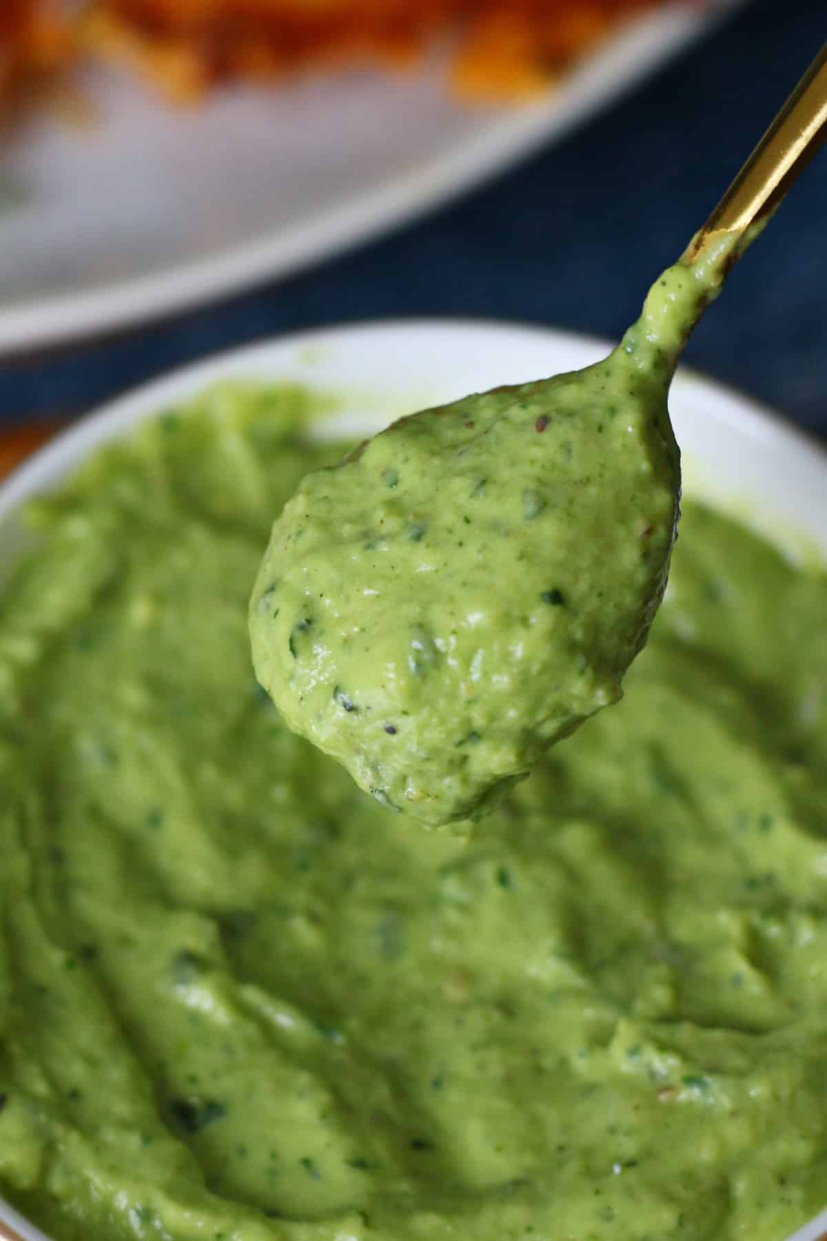 Creamy avocado sauce in a spoon.