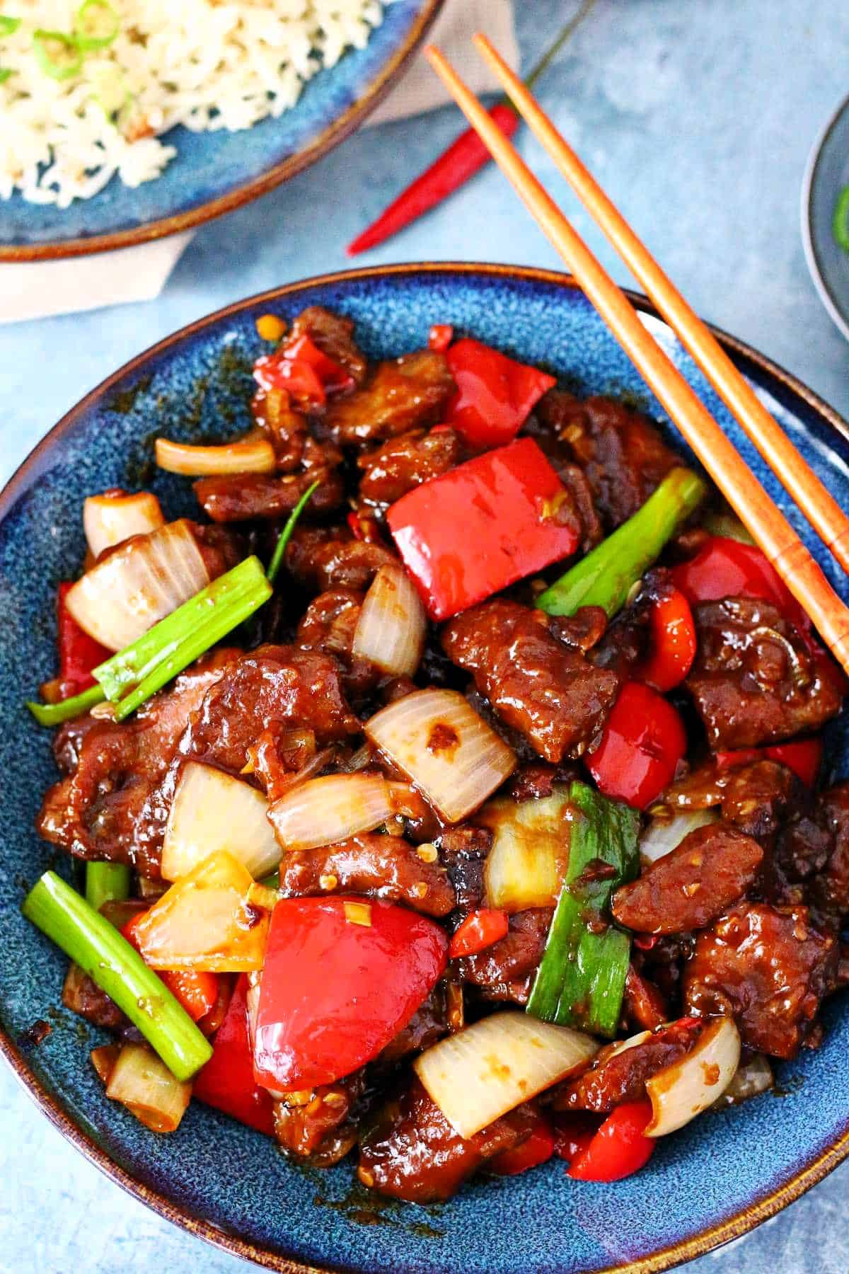 Overhead shot of Beijing Beef in a plate with chopsticks on the side.