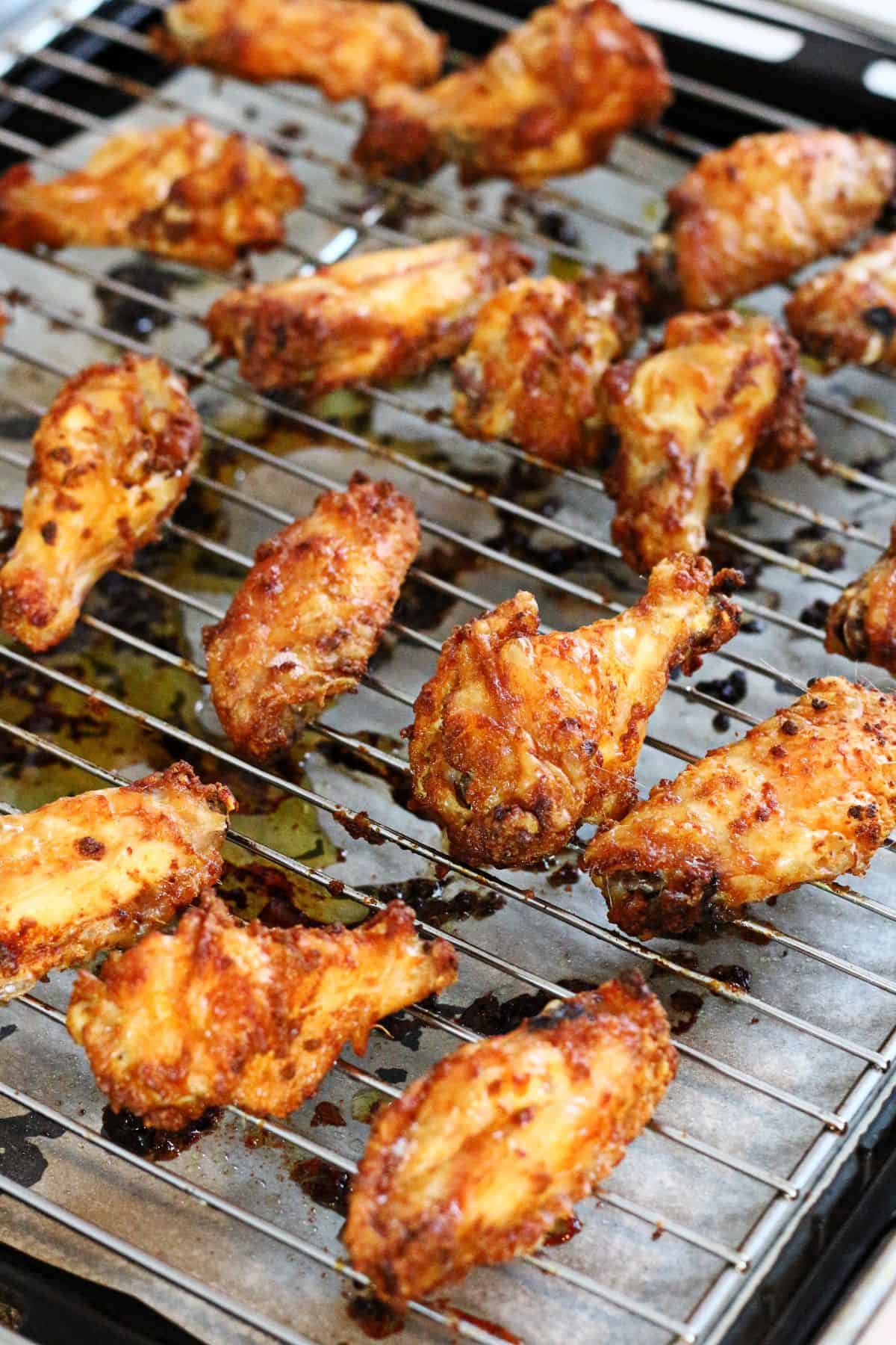 Oven baked chicken wings on a wire rack.