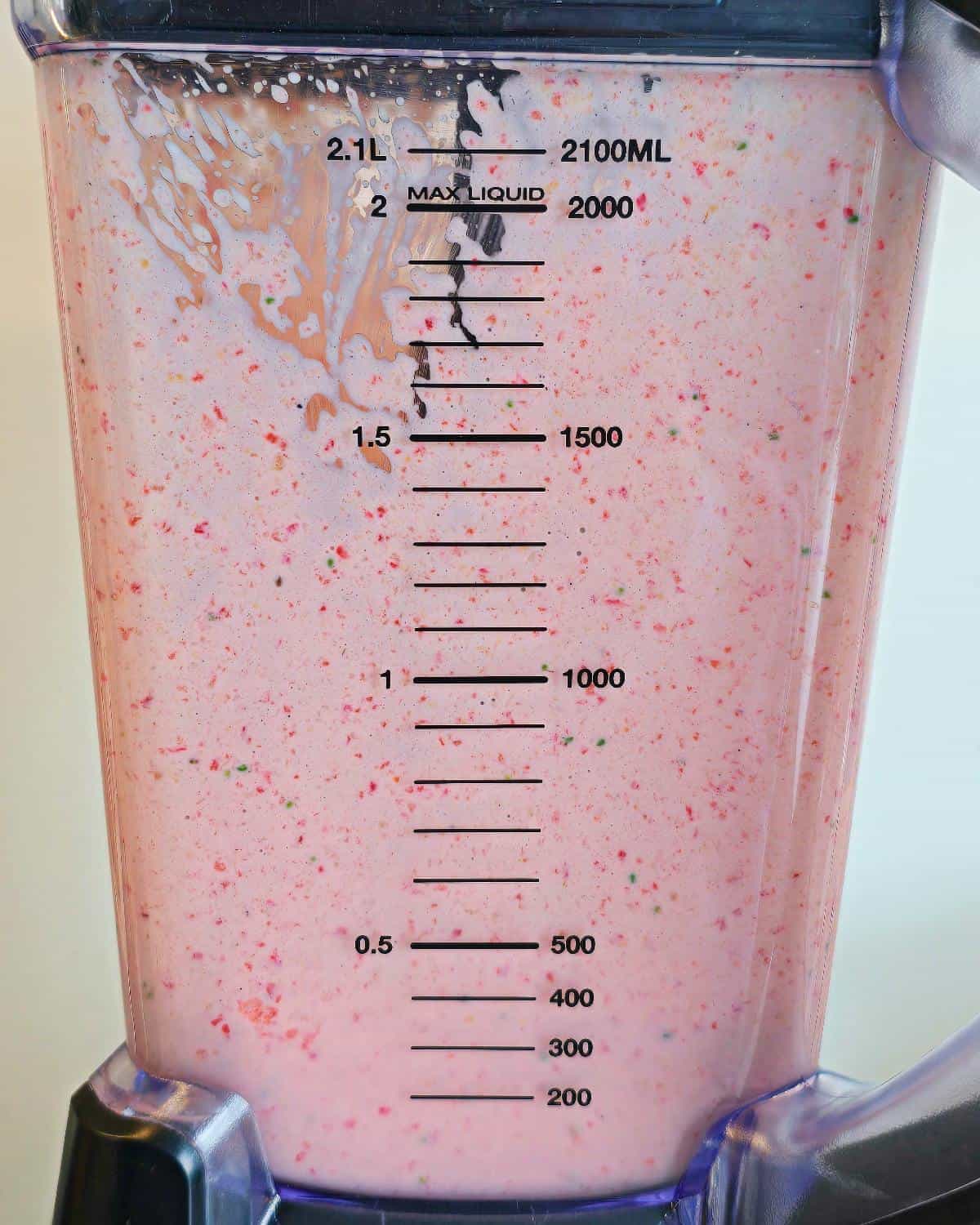 Blended strawberry milkshake in a blender.