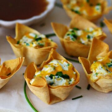 Wonton cups filled with cream cheese filling and topped with diced jalapeno.